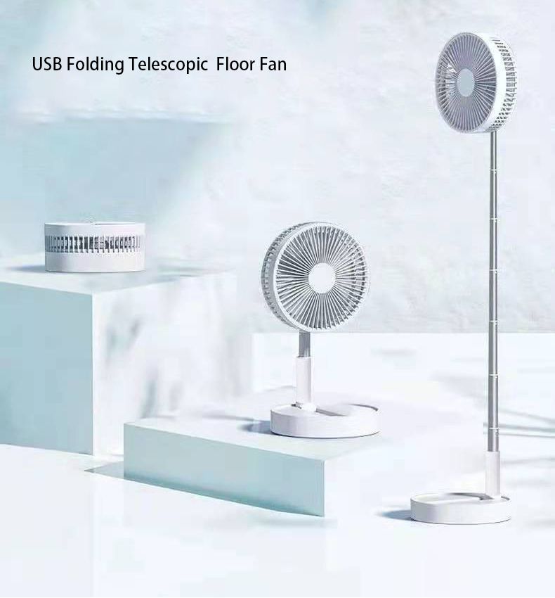 The image shows a white table fan sitting atop a white pedestal, with a USB folding telescopic floor fan beside it. The fan has a sleek, modern design with a textured surface and a handle on the top for easy portability. The text on the fan reads "USB Folding Telescopic Floor Fan" in bold, black lettering.