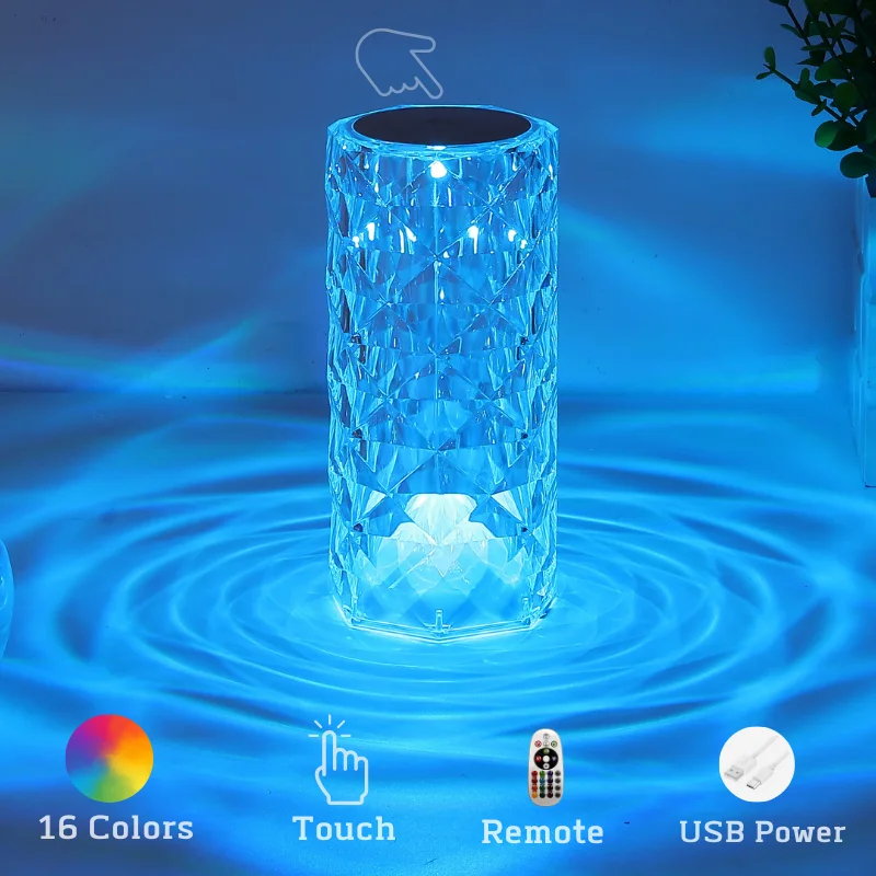 The image shows a glass vase sitting on top of a table next to a potted plant. The vase is illuminated with a colorful LED light, and there is text, a remote, and a watermark visible on the surface of the water. The background is slightly blurred, giving the image a dreamy feel.