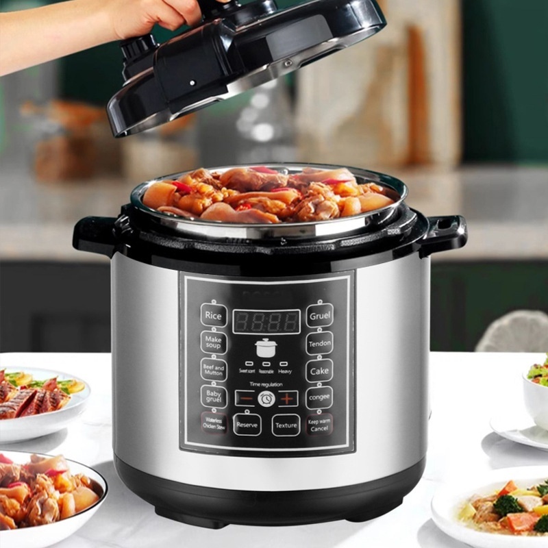 The image shows a person's hand holding a black electric pressure cooker. The pressure cooker is made of stainless steel and has a digital display on the front. It is placed on a kitchen countertop with two bowls of food in front of it. The food appears to be cooked and is in the pressure cooker, as there are small pieces of meat visible in the bowl. The background is blurred, but it seems like the person is in a kitchen or dining area.