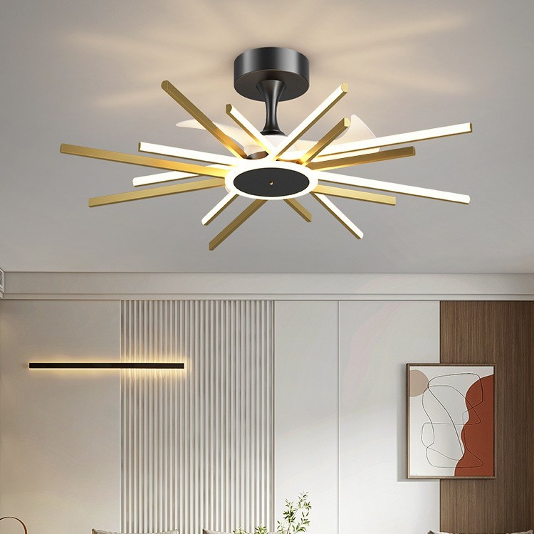 The image shows a modern ceiling light fixture in a living room. The fixture has a black base and a white circular light fixture with multiple wooden sticks arranged in a starburst pattern. The sticks are of different sizes and colors, creating a unique and eye-catching design. The light fixture is attached to the ceiling with a black metal bracket. On the right side of the image, there is a wooden door and a painting hanging on the wall. In the background, there are white walls and a wooden floor. The overall aesthetic of the room is minimal and contemporary.